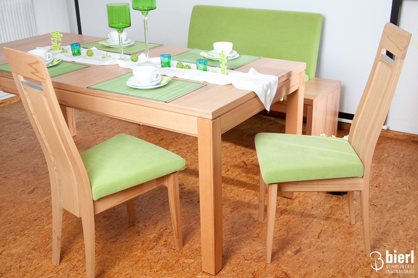 Heller Esszimmertisch mit grüner Stuhlpolsterung